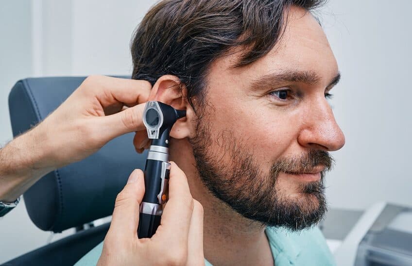 Adult Man During Ear Exam At Hearing Clinic. Audiologist Examini